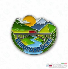 Scandi Pin Europabr�cke: Emaille-Anstecker mit LKW auf Br�cke, Berglandschaft, Fluss und Sonne.