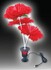 Beleuchtete rote Kunstblumen auf weien Stielen in schwarzem Standfu mit USB-Kabel.
