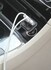 Schwarzes USB-Ladeger�t mit mehreren USB-Anschl�ssen, eingesteckt in eine LKW-Buchse. Zwei wei�e Kabel sind angeschlossen.